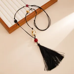 Close-up of handmade knotted choker with colorful resin beads and large black tassel