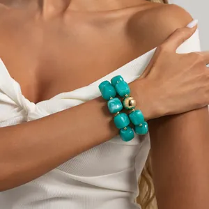 Dettaglio ravvicinato di un bracciale vintage in resina verde con grande perla