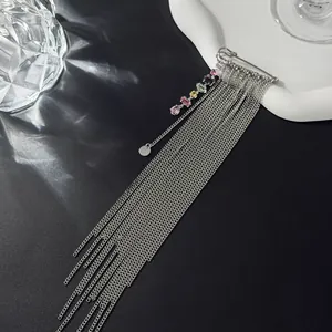 Detailed shot of a silver safety pin brooch with colorful crystals and long tassels