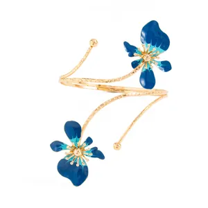 Vue détaillée d'un bracelet de bras doré avec des fleurs en émail bleu éclatant