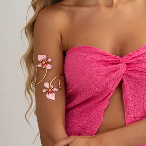Gros plan d'un élégant brassard à fleurs en émail rose avec fil doré sur un mannequin