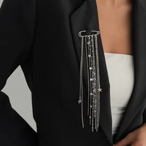 Elegant silver safety pin brooch featuring cascading chains and star charms on a black blazer