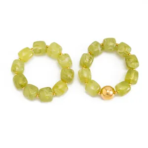 Dettaglio di due braccialetti in resina verde marmorizzata con accenti dorati