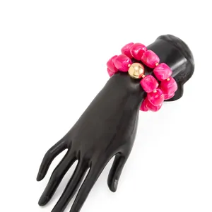 Dettaglio di bracciale in resina marmorizzata rosa vibrante su supporto nero