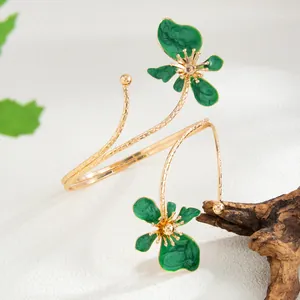 Détail d'un brassard en or avec des pétales de fleurs en émail vert texturé