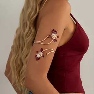 Vue détaillée d'un brassard doré double couche orné d'élégantes fleurs en émail rouge
