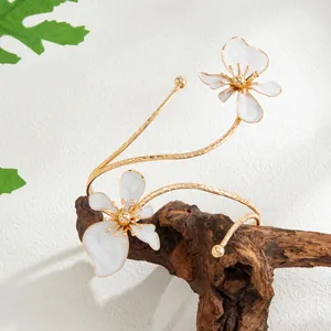 Détail du bracelet de bras doré avec fleurs à double couche laquées blanc émaillé