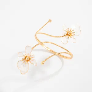 Bracelet de bras spirale doré élégant avec fleurs en émail blanc et détails texturés