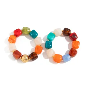 Vista dettagliata di bracciali in resina stile Maillard con perle marmorizzate colorate.