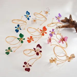 Bracelet de bras spirale doré avec des fleurs en émail colorées élégantes pour femmes.