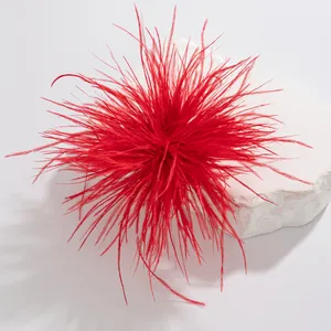 Detailed close-up showing the soft feather texture of a vibrant red brooch accessory