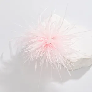 Close-up macro detail of a delicate light pink ostrich feather brooch for formal dresses