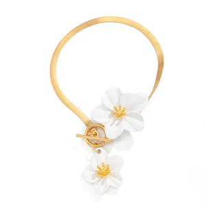 Detailed view of gold snake chain anklet with white enamel flowers and toggle clasp