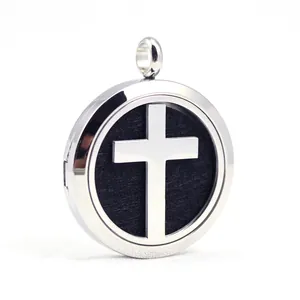 Close-up of stainless steel aromatherapy locket with hollow cross design and black pad