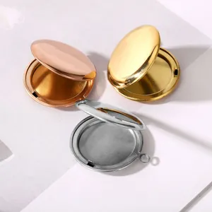 Vista de detalle de tres guardapelo redondos de acero inoxidable en oro, plata y oro rosa