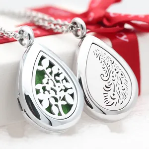 Detailed view of stainless steel teardrop aromatherapy lockets with tree and scroll patterns