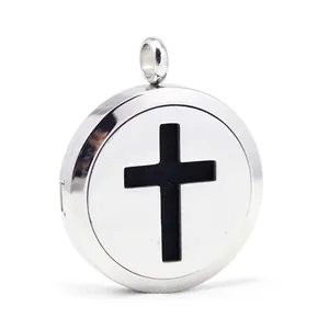 Close-up of stainless steel aromatherapy locket with hollowed-out cross design