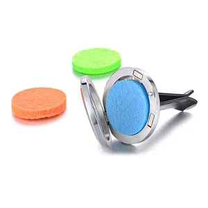 Detailed view of an open stainless steel car perfume clip with colorful refill felt pads