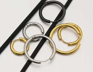 Primer plano de pendientes de aro de acero de titanio en colores plata, oro y negro