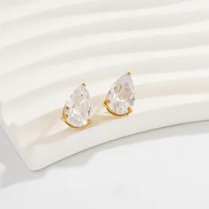 Close-up van elegante druppelvormige zirkonia oorbellen met vergulde edelstalen klauwen