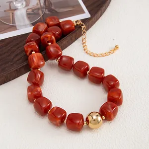Dettaglio della collana boho con cubi di resina ambra e una perla dorata lucida