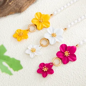 Vista detallada de tobilleras de flores coloridas con perlas y cierre OT de oro brillante
