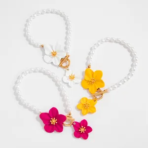 Close-up of vibrant flower pearl anklets with golden OT buckle for beach vacation