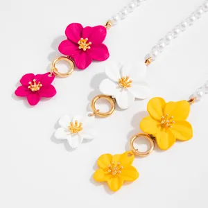 Detailed view of colorful enamel flower anklets featuring pearls and golden OT toggle buckles