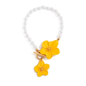 Detailed view of yellow enamel flowers and white pearl beads on a beach vacation anklet