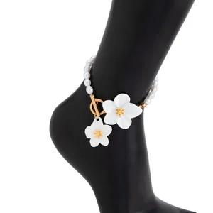 Detail of pearl anklet featuring white flowers and a gold-tone OT toggle clasp.