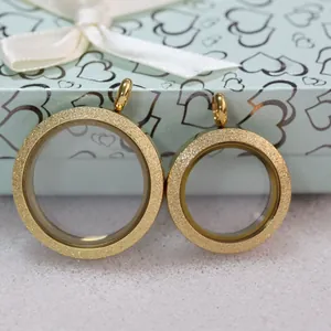Detailed view of two gold-plated magnetic glass floating charm lockets with frosted finish