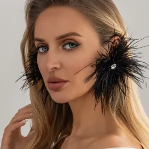Vue détaillée de boucles d'oreilles en plumes noires avec un strass central étincelant