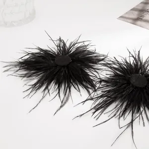 Vue détaillée montrant la texture douce des boucles d'oreilles en plumes d'autruche