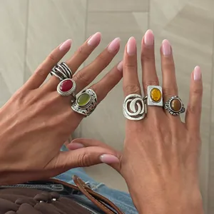 Close-up detail of model wearing French retro silver rings with colorful gemstones and carvings