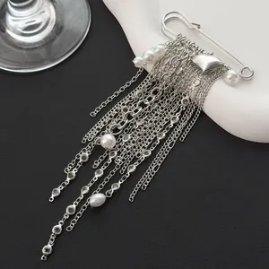 Elegant silver-toned tassel brooch featuring heart charm and white pearls detail shot