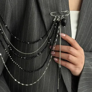 Punk hip-hop multi-layer chain brooch with black beads and heart charm on grey suit.