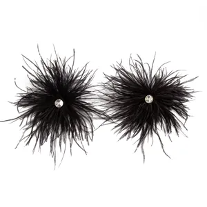 Gros plan sur d'élégantes boucles d'oreilles en plumes noires avec détail strass brillant