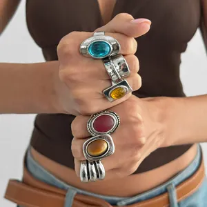 Vintage style rings with colorful gemstones in antique silver finish shown on hands.