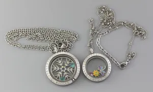 Detailed view of two stainless steel glass locket pendants with sparkling crystal bezels