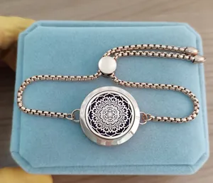 Close-up of rose gold diffuser bracelet with mandala pattern on blue velvet box