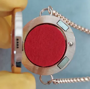 Detail of open rose gold aromatherapy locket showing internal red felt pad and magnets