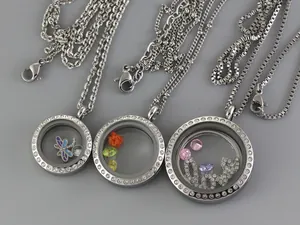 Detailed view of three sizes of silver floating locket necklaces with colorful charms