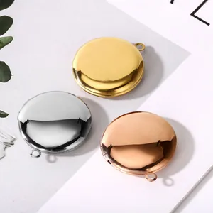 Tres colgantes guardapelo redondos de acero pulido en oro, plata y oro rosa fino.
