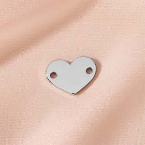 Polished stainless steel heart-shaped jewelry charm with double holes on pink satin