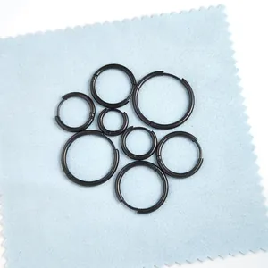 Juego de pendientes de aro de acero inoxidable negro en varios tamaños sobre tela