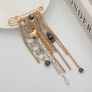 Macro view of multi-layer chain brooch with golden heart charm and beads