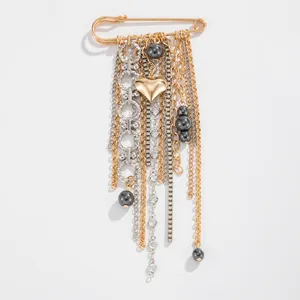 Detailed view of a fashionable heart safety pin brooch with layered metallic tassels and beads