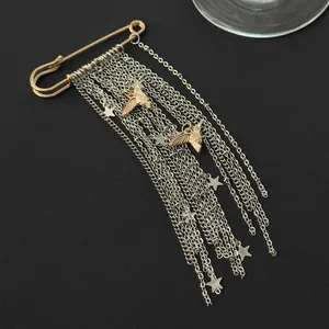 Close-up detail of stylish star tassel chain brooch with gold peace dove pendants