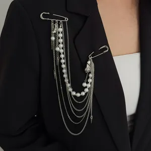 Gros plan d'une broche à pampilles en chaîne argentée avec perles sur un blazer noir