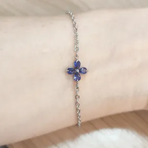 Detailed view of a silver chain bracelet featuring a blue zircon four-leaf clover pendant